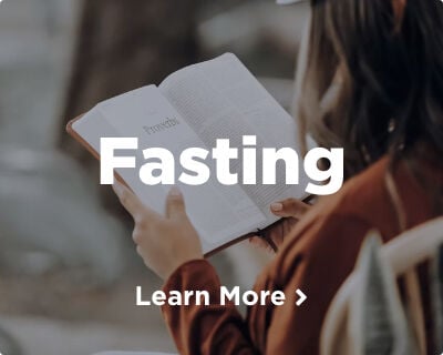 A woman, facing away from the camera, reading the Book of Proverbs. Explore the guide to Catholic fasting. Image links to related page.