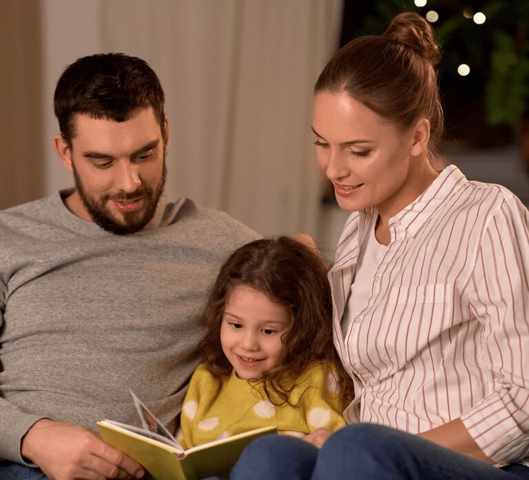 Parents reading to young daughter