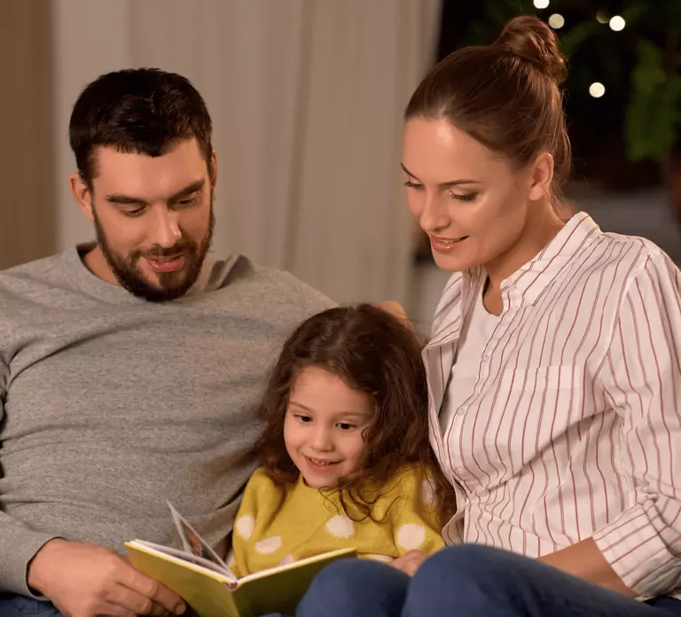 Parents reading to young daughter