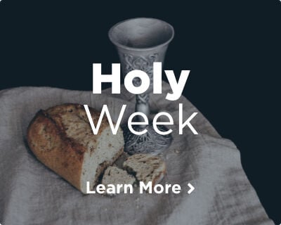 A silver chalice and a loaf of fresh bread, symbolizing the Body and Blood of Jesus, resting on a rustic white cloth. Image links to Holy Week page.