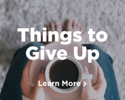 A woman's hands delicately holding a pink plate with a cup of coffee resting on it. Explore things to give up for Lent. Image links to a related page.